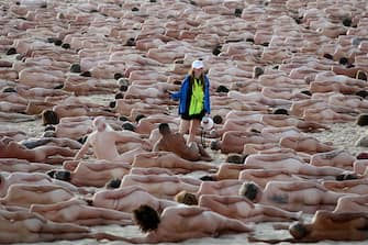 SYDNEY, AUSTRALIA - NOVEMBER 26: (EDITORS NOTE: Image contains nudity.) A crew member directs  people into position   at Bondi Beach on November 26, 2022 in Sydney, Australia. US artist and photographer Spencer Tunick created the nude installation using thousands of volunteers posing at sunrise on Bondi Beach, commissioned by charity Skin Check Champions to raise awareness of skin cancer and to coincide with National Skin Cancer Action Week. (Photo by Don Arnold/WireImage)