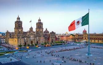 The Mexican flag flies over the Zocalo, the main square in Mexico City.  The Metropolitan Cathedral faces the square, also referred to as Constitution Square.