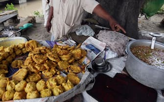 epa08626345 An Indian vendor shows Chutney or special sauce which he prepares to eat with Pakora, a famous snack, on a roadside in Amritsar, India, 26 August 2020.  EPA/RAMINDER PAL SINGH