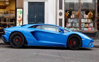London, Greater London, England, August 24 2021: Blue Lamborghini Aventador sports car with black wheels outside a book shop.