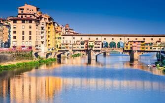 Florence, Tuscany - Ponte Vecchio, medieval bridge sunlighted over Arno River, Italy.