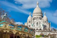 Paris, France - March, 2018: Carrousel and the Sacre Coeur Basilica at the Montmartre hill in Paris France