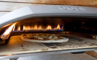 OONI Pizza oven with cooking pizza