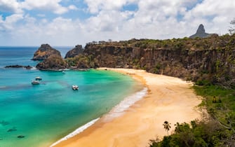 From the Golfinho-Sancho trail, it is possible to not only see the famous Sancho beach, and some of the slightly over 200 steps on the eastern side, but also see two of the more famous landmarks of Fernando de Noronha: O Pico, which is the highest point, and the Dois Irmaos ("two brothers"), which are just behind the eastern part of the Sancho beach.