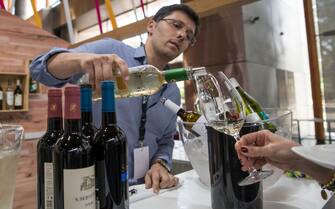 ESTORIL, PORTUGAL - JUNE 22: A server pours Centro region white wine at Turismo de Centro stand during lunch break  during the final day of MUST - Fermenting Ideas - Wine Summit 2018 on June 22, 2018 in Estoril, Portugal. Some of the top world wine masters meet for three days in Estoril to debate, discuss trends and question about the future of the wine world. (Photo by Horacio Villalobos - Corbis/Corbis via Getty Images)