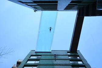 1232479699 A man swims in the Sky Pool, a transparent swimming pool bridge across two exclusive residential blocks standing next to the US Embassy in Nine Elms, south London, the first of its kind in the world. Picture date: Friday April 23, 2021. (Photo by Victoria Jones/PA Images via Getty Images)