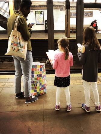 Children reading while waiting fir the subway