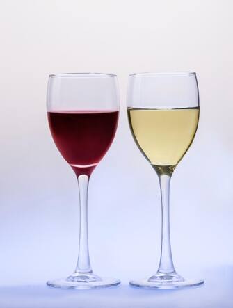 Red wine glass and white wine glass isolated on a light-blue background