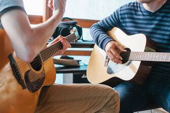 596345112 Learning to play the guitar. Music education and extra-curricular lessons.