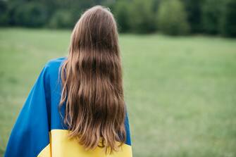1505759546 Ukraines Independence Flag Day. Constitution day. Ukrainian child girl in embroidered shirt vyshyvanka with yellow and blue flag of Ukraine in field. Flag symbols of Ukraine. Patriotic holiday.