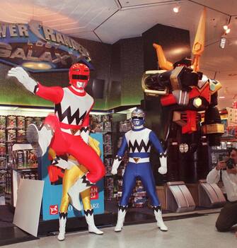 A Power Rangers character (L) jumps during unveiling of a Zord (R) from the new Power Rangers Lost Galaxy line of toys 09 February in New York. It is the latest release in the seven year history of the action figure toys from the Bandai company.  AFP PHOTO Stan HONDA (Photo by STAN HONDA / AFP) (Photo by STAN HONDA/AFP via Getty Images)