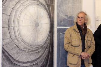 OBERHAUSEN, GERMANY - MARCH 15:  Bulgarian-born artist Christo poses in front of his paintings at an exhibition of his large-scale environmental art Big Air Package in a former gas storage facility called the Gasometer on March 15, 2013 in Oberhausen, Germany. The piece is made from 5.3 tons of translucent material covering 20,350 square meters and shaped with 4.500 meters of cable, and fills the interior of the facility. The installation will be open to the public from march 16 through December 30.  (Photo by Hannelore Foerster/Getty Images)