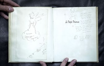 An original and signed copy of "Le Petit Prince" by late French author and aviator Antoine de Saint-Exupery, featuring a dedication to Doudou Chassin, is pictured at the Cazo auction house on December 2, 2016 in Paris, on the eve of their sale.
On December 3, Maison Cazo will be selling an original and signed copy of "Le Petit Prince" which will be accompanied by two drawings by author Antoine de Saint-Exupery. The copy for sale at Cazo is an original color edition of the French version of the Little Prince published in New York in 1943 by Reynal & Hitchcock. / AFP / PHILIPPE LOPEZ / RESTRICTED TO EDITORIAL USE - MANDATORY MENTION OF THE ARTIST UPON PUBLICATION - TO ILLUSTRATE THE EVENT AS SPECIFIED IN THE CAPTION        (Photo credit should read PHILIPPE LOPEZ/AFP via Getty Images)