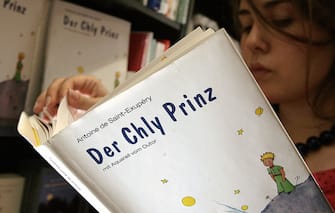BERN, SWITZERLAND:  TO GO WITH AFP STORY BY PAMELA TAYLOR A teen reads 24 May 2006 a Bernerdeutsch  editions of "Le Petit Prince" in a bookshop in Bern. To mark this year's 60th anniversary of the European publication of Antoine St. Exupery's "Le Petit Prince", a translation has appeared in Bernerdeutsch, the Swiss German dialect from the area of Bern, under the title "Der Chyl Prinz".  Historically standard German, or Hochdeutsch, has been the official written language for 64 percent of the Swiss population, followed by French (19 percent), Italian (8 percent) and a Latin dialect known as Romansch.                               AFP PHOTO FABRICE COFFRINI  (Photo credit should read FABRICE COFFRINI/AFP via Getty Images)
