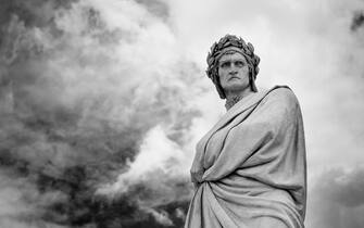 The brooding sculpture of Dante with a menacing sky that stands in front of the Santa Croce