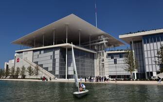 542761380 A man sails in front of the newly built Athens national Opera (L) and library buildings at the Stavros Niarchos Cultural Center in an Athens suburb on June 24, 2016.
A leading Greek foundation on Friday unveiled a sprawling new park, opera and national library in southern Athens designed to "give hope" to a country brought low by a six-year economic crisis. The 1,400-seat opera, library and adjoining park designed by famed Italian architect Renzo Piano cost nearly 600 million euros ($680 million) and took eight years to design and build. The new Stavros Niarchos Cultural Center, expected to fully open in mid-2017, occupies 20 hectares (50 acres) overall near the coast of Faliro in southern Athens. / AFP / LOUISA GOULIAMAKI (Photo credit should read LOUISA GOULIAMAKI/AFP via Getty Images)