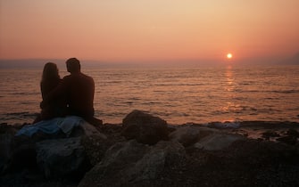 (GERMANY OUT) Paar sitzt bei Sonnenuntergang am Strand von Brela / Dalmatien / Kroatien- August 2001 (Photo by Hillmer/ullstein bild via Getty Images)