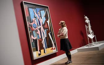 LONDON, ENGLAND - MARCH 06:  A woman poses in front of "The Three Dancers" (L) and "Woman in the Garden" by Pablo Picasso at the Tate Modern on March 6, 2018 in London, England.  "Picasso 1932: Love, Fame and Tragedy" is the first solo exhibition at Tate Modern of the artist's work and includes more than 100 works.  (Photo by Leon Neal/Getty Images)