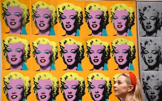 A gallery assistant poses with an artwork entitled "Marilyn Diptych" 1962," by US artist Andy Warhol during a press preview for the forthcoming Andy Warhol exhibition at the Tate Modern in London on March 10, 2020. - The exhibition is set to run from March 12 to September 6. (Photo by Justin TALLIS / AFP) / RESTRICTED TO EDITORIAL USE - MANDATORY MENTION OF THE ARTIST UPON PUBLICATION - TO ILLUSTRATE THE EVENT AS SPECIFIED IN THE CAPTION (Photo by JUSTIN TALLIS/AFP via Getty Images)