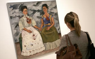 LONDON, UNITED KINGDOM:  A woman stands in front of "The Two Fridas", part of the Frida Kahlo exhibition at the Tate Modern in London, 07 June, 2005. It is the first major exhibition in over twenty years devoted to the Mexican artist.    AFP PHOTO / JOHN D MCHUGH  (Photo credit should read JOHN D MCHUGH/AFP via Getty Images)