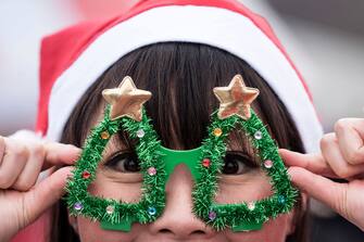 TOKYO, JAPAN - DECEMBER 22:  A participant wearing a Santa Claus costume poses for a photograph during the Tokyo Great Santa Run 2019 on December 22, 2019 in Tokyo, Japan. Over 3,000 people took part in the charity run event today. The profit of the event will be used for sick children staying in hospitals in Japan and for the clean water project in Maasai communities in Kenya.  (Photo by Tomohiro Ohsumi/Getty Images)