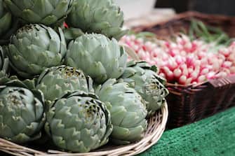 Artichokes and radishes are displayed at a market in Paris on May 31, 2018. (Photo by Ludovic MARIN / AFP)        (Photo credit should read LUDOVIC MARIN/AFP via Getty Images)