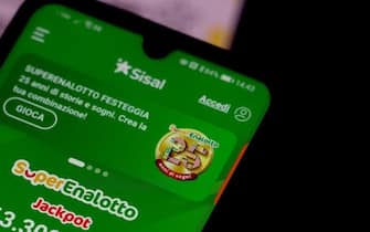 ROME, ITALY - FEBRUARY 03:  A woman plays Italy's main lottery known as SuperEnaLotto with a dedicated app on her smartphone  on February 03, 2023 in Rome, Italy.  Superenalotto' Italian Lottery record jackpot has reached approximately 363 million euros (about USD$396 million). To win, people must select six numbers at random between one and 90. (Photo by Franco Origlia/Getty Images)