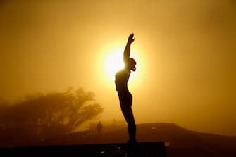 AUCKLAND, NEW ZEALAND - MAY 04:  A lady practices yoga on the summit of Mt Eden as the sun struggles to shine through a blanket of fog over Auckland City on May 4, 2016 in Auckland, New Zealand. The morning fog disrupted flights and ferry services in the city.  (Photo by Phil Walter/Getty Images)