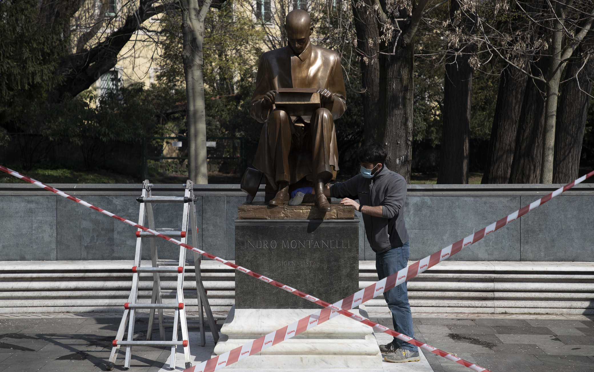 Dopo che ieri la statua di Indro Montanelli situata nei giardini di Porta Venezia è stata nuovamente imbrattata, i restauratori puliscono i graffiti fatti con la vernice, Milano, 12 marzo 2021. ANSA/ MARCO OTTICO
