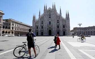 Alcune persone in piazza Duomo semi deserta nella fase 2 dell'emergenza Coronavirus a Milano, 7 maggio 2020.ANSA/Mourad Balti Touati