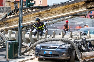 Vigili del fuoco e forze dell'ordine sul luogo dove una trivella alta oltre 10 metri è precipitata dall'interno di un cantiere abbattendosi sulla strada e danneggiando il palazzo antistante a Milano, 15 Giugno 2021. ANSA/Andrea Fasani