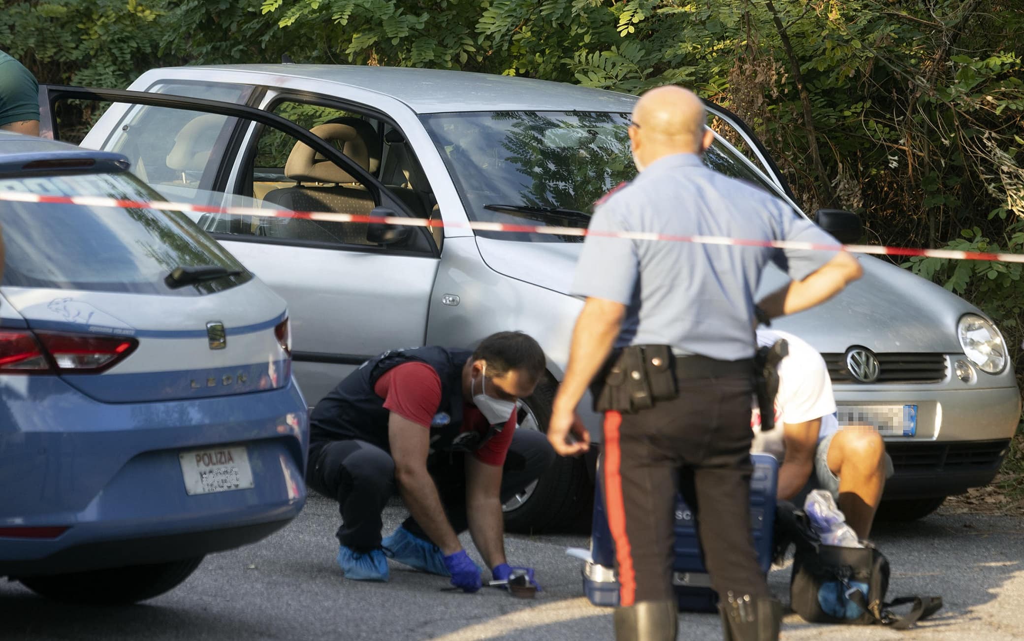 Agenti di Polizia al lavoro vicino alla macchina dove è stata rinvenuto il corpo di una persona in via Giussani a Como, 11 Agosto 2022ANSA / MATTEO BAZZI