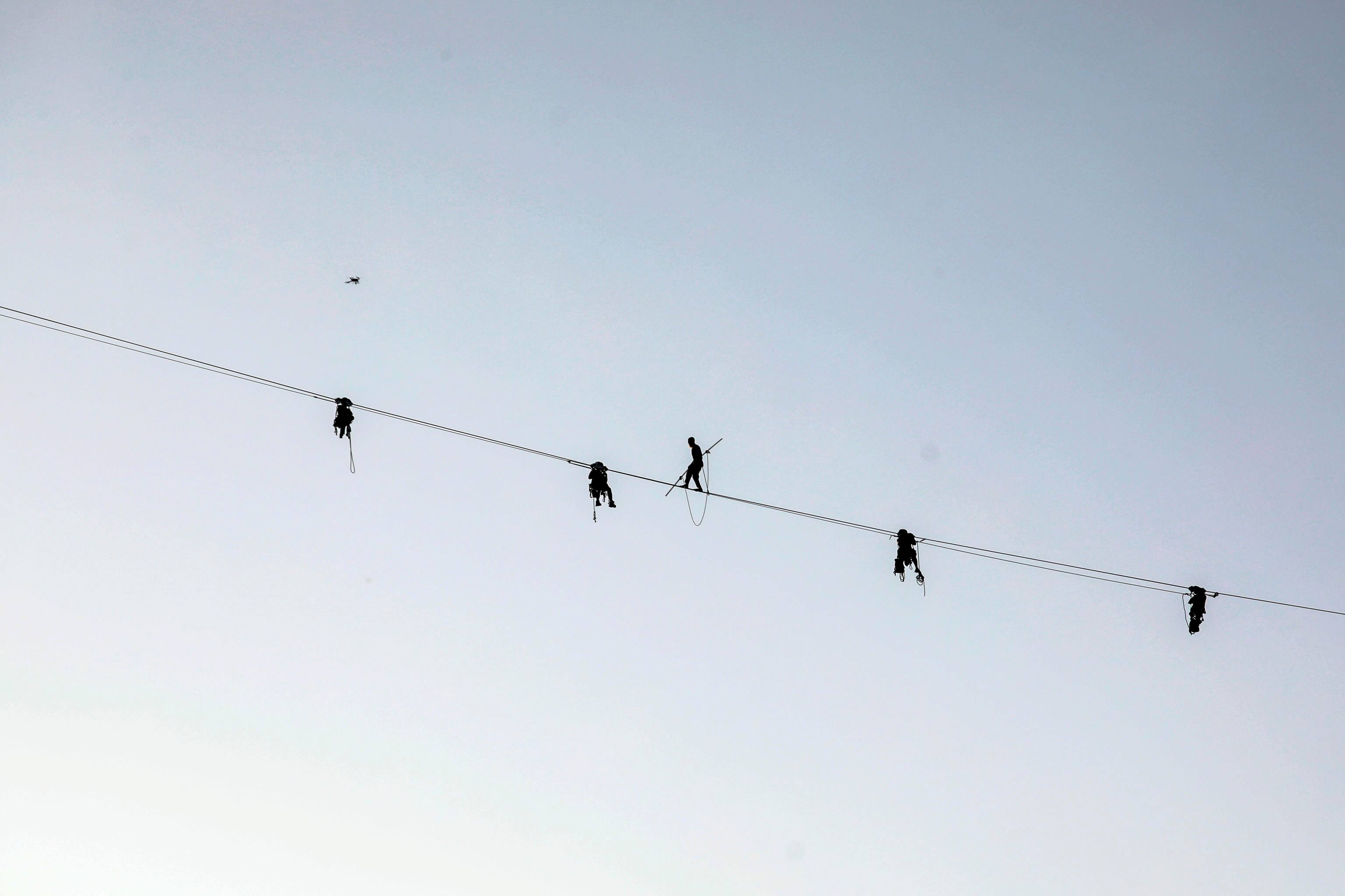 Il funambolo Andrea Loreni si cimenta nella prima traversata funambolica camminando a 140 metri di altezza dal Bosco Verticale all'Unicredit Tower a Milano, 26 maggio 2023.ANSA/MOURAD BALTI TOUATI

