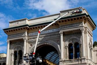 Lavori di pulizia dei graffiti sul frontone della Galleria Vittorio Emanuele II a Milano, 9 agosto 2023. ANSA/MOURAD BALTI TOUATI
