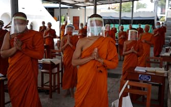epa08401679 Novice Thai Buddhist monks wearing face shields and protective face masks, attend a lesson at Wat Molilokayaram monastic educational institute in Bangkok, Thailand, 16 April 2020 (issued 05 May 2020). The traditional Buddhist temples in Thailand have adopted innovative measures like setting up sanitizing tunnels and making masks to join the fight against COVID-19. Not only have the monks added an orange mask to their attire - which has remained largely unchanged since the time of Buddha (2,500 years ago) - but also make their own sanitizers. They have also been distributing food to those who have lost their incomes due to the crisis. Several monasteries have completely stopped going out for morning alms while some have reduced the numbers of monks going outside, while wearing protective masks and sometimes face shields in an effort to help prevent the spread of the COVID 19 disease pandemic caused by the SARS CoV-2 coronavirus.  EPA/DIEGO AZUBEL  ATTENTION: This Image is part of a PHOTO SET