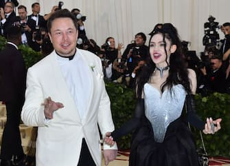 Elon Musk and Grimes arrive for the 2018 Met Gala on May 7, 2018, at the Metropolitan Museum of Art in New York. - The Gala raises money for the Metropolitan Museum of Arts Costume Institute. The Gala's 2018 theme is Heavenly Bodies: Fashion and the Catholic Imagination. (Photo by ANGELA WEISS / AFP)        (Photo credit should read ANGELA WEISS/AFP via Getty Images)
