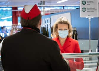1211915697 Queen Mathilde of Belgium (R) wearing a protective mask speaks with a worker as she visits the Carrefour supermarkets of Mestdagh groupe in Gerpinnes, on May 6, 2020 during a novel coronavirus (COVID-19) pandemic. (Photo by Benoit DOPPAGNE / BELGA / AFP) / Belgium OUT (Photo by BENOIT DOPPAGNE/BELGA/AFP via Getty Images)