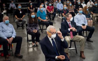 People wait for US President Donald Trump to speak at a Honeywell International Inc. factory during his first trip since widespread COVID-19 related lockdowns went into effect May 5, 2020, in Phoenix, Arizona. (Photo by Brendan Smialowski / AFP) (Photo by BRENDAN SMIALOWSKI/AFP via Getty Images)