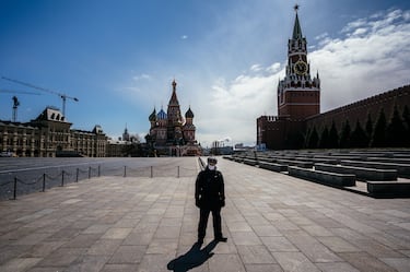A law enforcement officer stands guard on the deserted Red Square in front of St. Basil's Cathedral and the Kremlin's Spasskaya Tower in downtown Moscow on April 22, 2020, during a strict lockdown in Russia to stop the spread of the novel coronavirus COVID-19. (Photo by Dimitar DILKOFF / AFP) (Photo by DIMITAR DILKOFF/AFP via Getty Images)