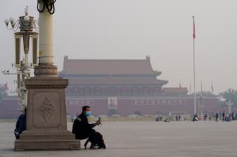 BEIJING, CHINA - MAY 01: A person watches the flag-raising ceremony at the Tiananmen Square in Beijing at daybreak on May 1, 2020. The day marks a national holiday in China, celebrating the International Workers Day. Life in Beijing is slowly returning to normal following a city-wide lockdown on January 25 to contain the coronavirus (COVID-19) outbreak. the upcoming Chinese Labor Day holidays will take place 01 to 05 May.(Photo by Fred Lee/Getty Images)