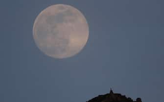 epa08406540 A full moon sits over Sacro Peak close to the town of Santiago de Compostela, Spain, 06 May 2020 (issued on 07 May 2020).  EPA/Lavandeira Jr.