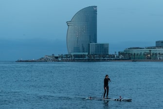 BARCELONA, SPAIN - MAY 08: Melani Asmann practices paddle surf at dawn at La Barceloneta Beach opened for the first day since March 15 during the novel coronavirus crisis on May 08, 2020 in Barcelona, Spain. Permitted activities now include outdoor water sports such as surfing, paddle boarding or swimming from 6 - 10 AM and from 8 - 11 PM, with beaches only open for sporting activities such as running, working out or water sports. Spain has had more than 220,000 confirmed cases of COVID-19 and over 26,000 reported deaths, although the rate has declined after weeks of lockdown measures.  (Photo by David Ramos/Getty Images)