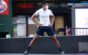 1223542981 NEW YORK, NEW YORK - MAY 07: A man wearing a protective mask exercises in Times Square as daily life continues amid the coronavirus outbreak on May 07, 2020 in New York City. COVID-19 has spread to most countries around the world, claiming over 270,000 lives and infecting over 3.9 million people. (Photo by John Lamparski/Getty Images)