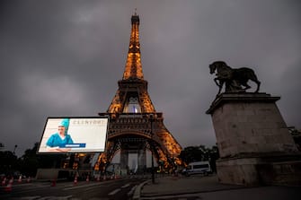 1212472655 A portrait of a nurse who was mobilized during the COVID-19 pandemic and pictures of other representatives of professional groups are displayed during a tribute on a giant screen in front of The Eiffel Tower in Paris on May 10, 2020, on the eve of France's easing of lockdown measures in place for 55 days to curb the spread of the pandemic, caused by the novel coronavirus. (Photo by Thomas SAMSON / AFP) (Photo by THOMAS SAMSON/AFP via Getty Images)