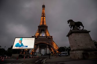 A portrait of a nurse who was mobilized during the COVID-19 pandemic and pictures of other representatives of professional groups are displayed during a tribute on a giant screen in front of The Eiffel Tower in Paris on May 10, 2020, on the eve of France's easing of lockdown measures in place for 55 days to curb the spread of the pandemic, caused by the novel coronavirus. (Photo by Thomas SAMSON / AFP) (Photo by THOMAS SAMSON/AFP via Getty Images)