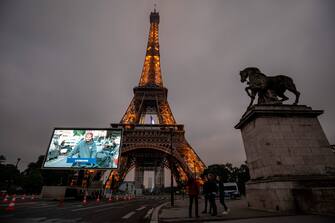 A portrait of deliverer who was mobilized during the COVID-19 pandemic and pictures of other representatives of professional groups are displayed during a tribute on a giant screen in front of The Eiffel Tower in Paris on May 10, 2020, on the eve of France's easing of lockdown measures in place for 55 days to curb the spread of the pandemic, caused by the novel coronavirus. (Photo by Thomas SAMSON / AFP) (Photo by THOMAS SAMSON/AFP via Getty Images)
