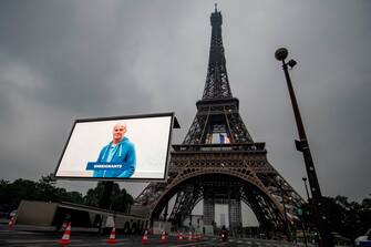 A portrait of a teacher who was mobilized during the COVID-19 pandemic and pictures of other representatives of professional groups are displayed during a tribute on a giant screen in front of The Eiffel Tower in Paris on May 10, 2020, on the eve of France's easing of lockdown measures in place for 55 days to curb the spread of the pandemic, caused by the novel coronavirus. (Photo by Thomas SAMSON / AFP) (Photo by THOMAS SAMSON/AFP via Getty Images)