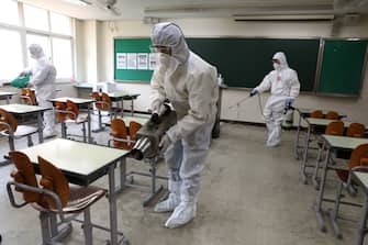SEOUL, SOUTH KOREA - MAY 11: Disinfection professional and government official wearing protective clothing spray anti-septic solution at classroom to prevent the spread of the coronavirus (COVID-19) ahead of school re-opening on May 11, 2020 in Seoul, South Korea. South Korea's education ministry announced plans to re-open schools starting from May 13, more than two months after schools were closed in a precautionary measure against the coronavirus. Coronavirus cases linked to clubs and bars in Seoul's multicultural district of Itaewon have jumped to 54, an official said Sunday, as South Korea struggles to stop the cluster infection from spreading further. According to the Korea Center for Disease Control and Prevention, 35 new cases were reported. The total number of infections in the nation tallies at 10,909. (Photo by Chung Sung-Jun/Getty Images)