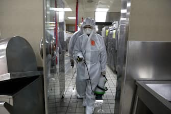 SEOUL, SOUTH KOREA - MAY 11: Disinfection professionals wearing protective clothing spray anti-septic solution at cafeteria to prevent the spread of the coronavirus (COVID-19) ahead of school re-opening on May 11, 2020 in Seoul, South Korea. South Korea's education ministry announced plans to re-open schools starting from May 13, more than two months after schools were closed in a precautionary measure against the coronavirus. Coronavirus cases linked to clubs and bars in Seoul's multicultural district of Itaewon have jumped to 54, an official said Sunday, as South Korea struggles to stop the cluster infection from spreading further. According to the Korea Center for Disease Control and Prevention, 35 new cases were reported. The total number of infections in the nation tallies at 10,909. (Photo by Chung Sung-Jun/Getty Images)