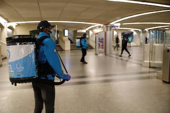 RATP employees carry a load of hydroalcoholic gel in order to disinfect commuters' hands as they arrive at a metro station, on May 11, 2020 in Paris, as the lockdown introduced two months ago to fight the spread of the Covid-19 disease caused by the novel coronavirus starts to ease. (Photo by GEOFFROY VAN DER HASSELT / AFP) (Photo by GEOFFROY VAN DER HASSELT/AFP via Getty Images)